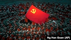Izvođači obučeni kao spasioci okupljaju se oko zastave Komunističke partije tokom gala predstave uoči 100. godišnjice osnivanja Komunističke partije Kine u Pekingu, 28. Juna 2021. Foto: Ng Han Guan (AP)