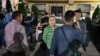 Дамира Ниязалиева тинтүү жүрүп жаткан шайлоо штабынын алдында турат, 29-май, 2023-жыл.