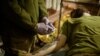 Një ushtar i plagosur ukrainas në një pikë të stabilizimit, para se të dërgohet në një spital për trajtim të mëtejmë mjekësor. 