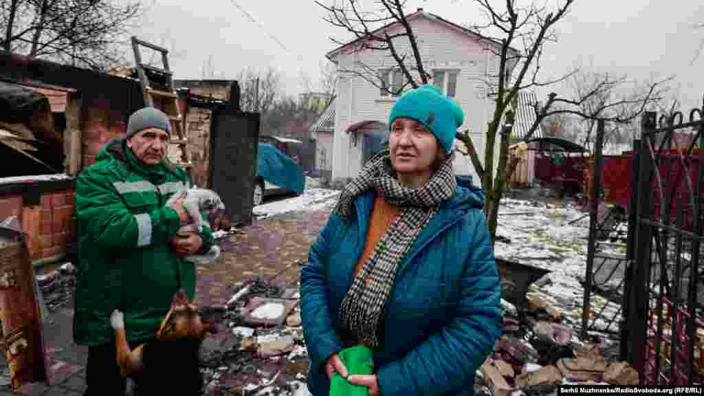 Місцеві жителі Наталя і Рустем: «Будинок цілий, але те, що цеглинка до цеглинки сама викладала, сама складала, – на старості літ вирішили, щоб жити легше було. Бачите, як сталося – тепер починати спочатку? Дуже важко, дуже страшно було сидіти в підвалі, як оце все гуркотіло. Думали, у нас найбезпечніша зона. А бачите, як вийшло». Місто Буча, Київська область, 1 березня 2022 року. Наталя на фото в лютому 2023 року (праворуч): «Всі поруч, всі живі»