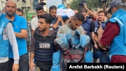 Kolega nosi okrvavljeni prsluk palestinskog novinara Mohameda Soboha, ubijenog zajedno sa još dvoje novinara kada je izraelska granata pogodila zgradu ispred koje su izvještavali, Gaza, 10. oktobra 2023.