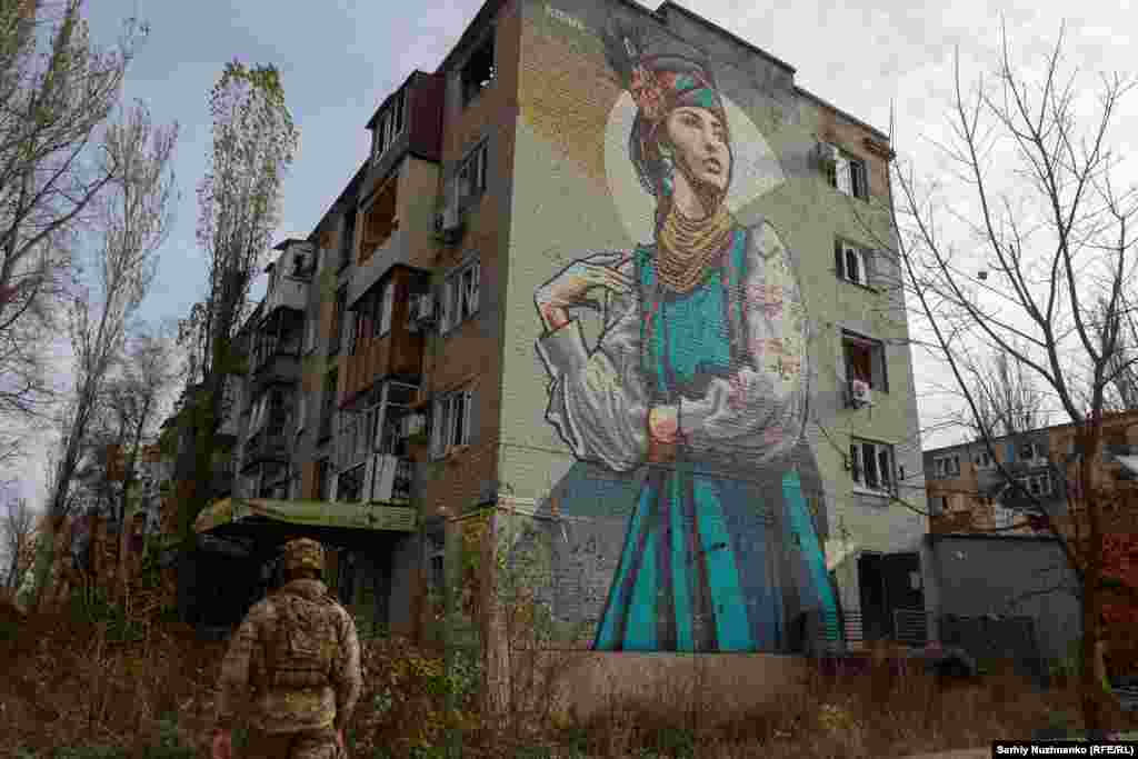 Un soldat ucrainean lângă o clădire de apartamente avariată. Un important nod de trafic, Avdiivka, se află la doar 15 kilometri nord de orașul Donețk, ocupat de Rusia. Acesta se află sub asediu de când Moscova a lansat o ofensivă majoră la începutul lunii octombrie.