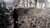 Чоловік в Авдіївці оглядає свіжу вирву в центрі його рідного міста після російського обстрілу. Фото: Якуб Лайхтер (©)
