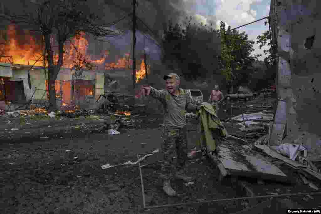 Украинский военнослужащий обращается к парамедикам, стоя у тел погибших в результате ракетного обстрела продовольственного рынка в Константиновке, Украина, 6 сентября 2023 года. Удар унёс жизни 15 человек. Американская газета New York Times пришла к выводам, что удар произошёл в результате падения украинской зенитной ракеты, возможно, из-за неисправности. Официальный Киев отрицает это, обвиняя в атаке российских военных. AP/Evgeniy Maloletka
