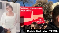 Әйелдерге зорлық-зомбылық жасауға қарсы митингіге шыққан қыз марқұм Салтанат Нүкенованың суретін ұстап тұр.