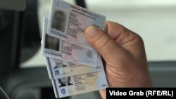 Një serb nga Kosova duke mbajtur në duar letërnjoftimet e tij të lëshuara nga Serbia dhe nga Kosova. Fotografi ilustruese nga arkivi. 