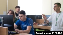 Serghei Covali (centru) din Râșcani, ajutat de voluntari să se înregistreze pe platforma eAdmitere și să depună actele.