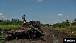 Український військовий оглядає знищений російський танк у Новодарівці, Запорізька область, 21 липня 2023 року