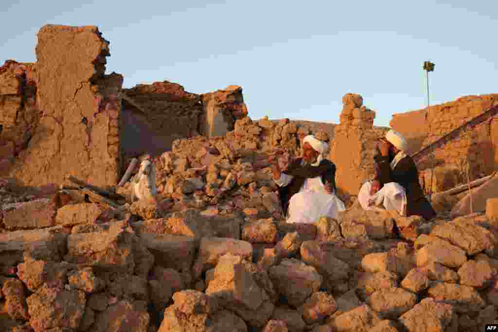  دوه زلزله ځپلي په یوه ویجاړ شوي کور کې سره ناست دي