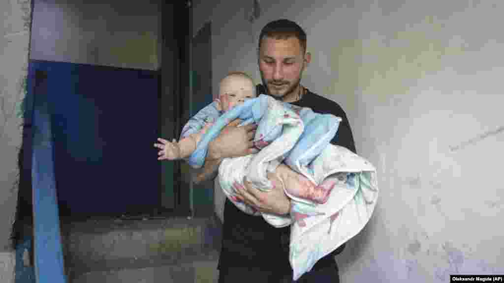 Чоловік виносить дитину із будинку, який був пошкоджений внаслідок російського ракетного удару по Первомайському. 4 липня 2023 року За повідомленнями влади, наймолодшим із 12-ти постраждалих дітей (усього поранення отримали 43 цивільні людини) є 3-місячне немовля. 