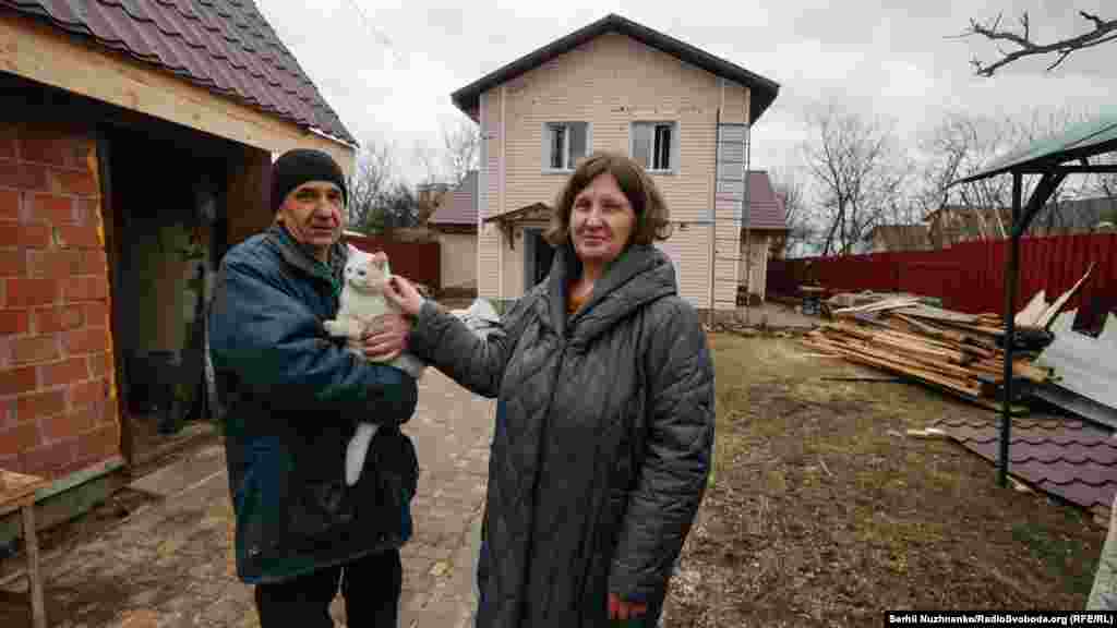 Місцеві жителі Наталя і Рустем: «Будинок цілий, але те, що цеглинка до цеглинки сама викладала, сама складала, – на старості літ вирішили, щоб жити легше було. Бачите, як сталося – тепер починати спочатку? Дуже важко, дуже страшно було сидіти в підвалі, як оце все гуркотіло. Думали, у нас найбезпечніша зона. А бачите, як вийшло». Місто Буча, Київська область, 1 березня 2022 року. Наталя на фото в лютому 2023 року (праворуч): «Всі поруч, всі живі»