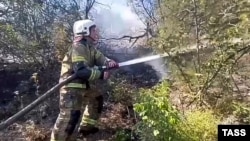 A handout photo from the Russian Emergencies Ministry shows a firefighter at the scene of a fire near Khutor Dyurso, in southern Russia, on July 14.