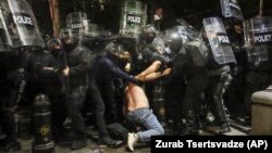 Forțele de ordine arestând un demonstrant pro-european la 1 mai, la Tbilisi. Criticii legii „agenților străini”, care a declanșat protestele repetate, spun că ea blochează parcursul european al țării.