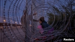 HRW avertizează că întoarcerea lui Trump este o știre proastă mai ales pentru cei aflați în căutarea unei vieți mai bune, ca Elina, o imigrantă din Venezuela, care este oprită cu bebelușul în brațe la El Paso, în Texas, într-o fotografie din martie 2024. 
