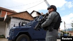 Një pjesëtar i njësisë speciale të Policisë së Kosovës në gatishmëri, pas arrestimit të një personi të identifikuar si organizator i protestave të dhunshme të muajit maj, në Mitrovicën e Veriut, Kosovë, më 13 qershor 2023.