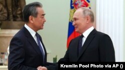 Голова канцелярії Комісії з закордонних справ Центрального комітету Комуністичної партії Китаю Ван Ї (ліворуч) і президент Росії Володимир Путін. Москва, 22 лютого 2023 року