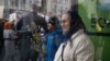 Femeie într-o stație de autobuz în apropiere de Primăria Chișinăului, urmărind Marșul Feminist, pe 8 martie 2024 