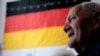 Gradiska, BiH, adult man sitting and smiling, with the German flag in background