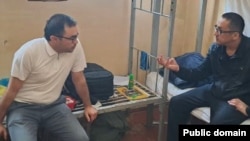 Өзбекстанның адам құқығы жөніндегі уәкілінің өкілі қамауда отырған Дәулетмұрат Тәжімұратовпен (оң жақта) кездесіп отыр. 2023 жылдың мамыр айында жарияланған сурет.