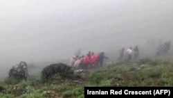 Фотографија направена од видео објавено од иранската Црвена полумесечина на која спасувачи извлекуваат тела од местото на падот на хеликоптерот на претседателот Ебрахим Раиси во планинскиот регион прекриен со магла во северозападен Иран, 20 мај 2024 година