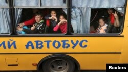 Copii luându-și rămas-bun în timpul evacuării din orașul Kupiansk, ocupat de Rusia, în apropierea orașului Harkov, 30 mai 2022.