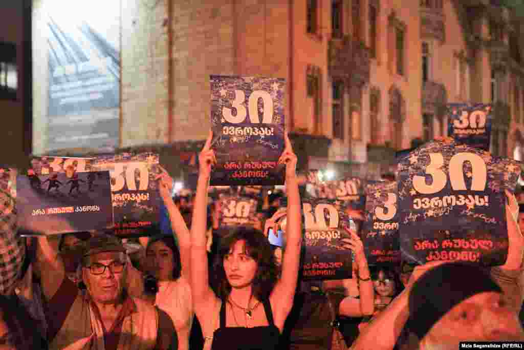 Protestatarii poartă pancarte pe care scrie „Da Europei” și „Nu legii rusești”.