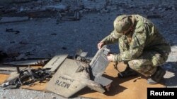 Поліцейська оглядає частини безпілотного літального апарату «Шахед-136» на місці російського удару по сховищах пального у Харкові, Україна, 6 жовтня 2022 року. Фото ілюстративне