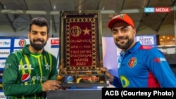 د افغانستان او پاکستان ترمنځ د روانې شل اوره سیالۍ د اتلولۍ جام چې د دواړو هېوادونو د لوبډلمشرانو راشدخان او شاداب خان ورسره ولاړ دي. افغان کرکټ بورډ ویلي، دغه جام له افغانۍ غالۍ جوړ شوی دی.