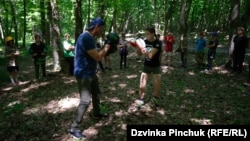 Серхи Золотаренко, боксерски тренер од блискиот Черкаси и неговата ученичка Дијана Птеренко, одржуваат час за деца во летен камп во Украина, лето 2024 