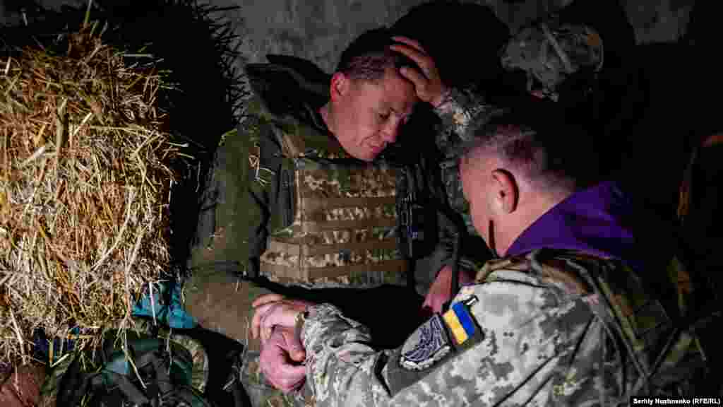 Вайсковы капэлян Аляксандар дабраслаўляе ўкраінскага вайскоўца на паўночным усходзе Харкаўскай вобласьці, 24 красавіка 2022