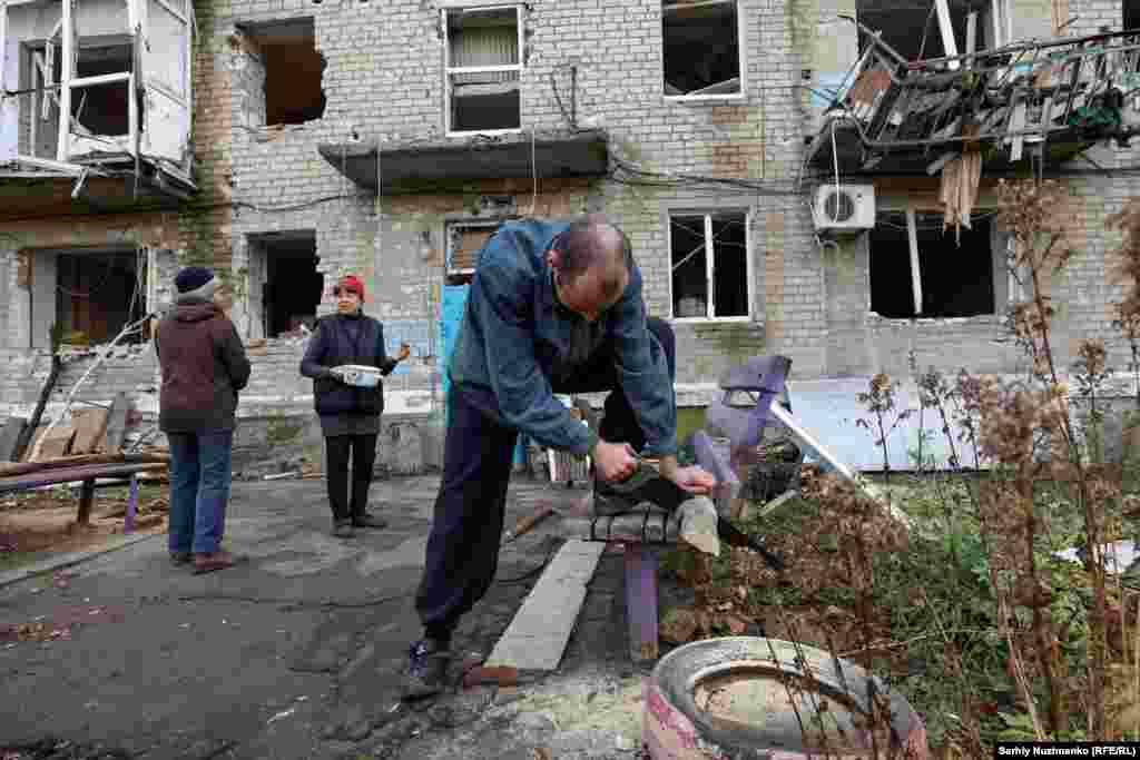 Олександър реже дърва за огрев. Въпреки че в Авдиивка има "точка на непобедимост" - център за хуманитарна подкрепа, предлагащ храна, топлина и убежище, вече е изключително опасно за жителите да се осмеляват да го посещават. 