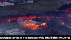 Fotografija Civilne zaštite naprvljena iznad Grindavika prikazuje lavu od erupcije pored kuća 14. januar 2024.
