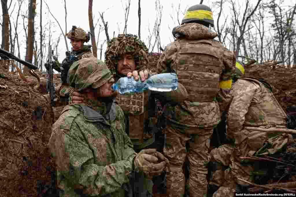 Расейскаму вайскоўцу даюць ваду пасьля яго захопу ўкраінскімі войскамі непадалёк ад Бахмуту, травень 2023 