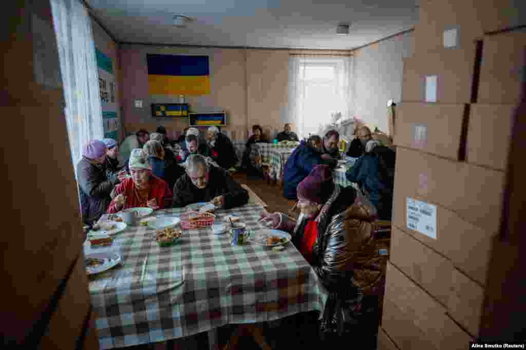 Люди обідають у притулку для внутрішньо переміщених осіб 