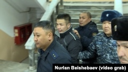 Мурдагы аялынын кулак-мурдун кескилеген Азамат Эстебесовду сот залына алып келаткан учур. 26-январь, 2024-жыл. 