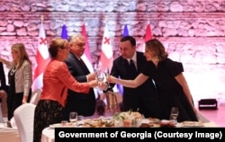 Orban și Garibașvili, împreună cu soțiile lor, ciocnesc un pahar de șampanie în Ținandali, Georgia, pe 10 octombrie.