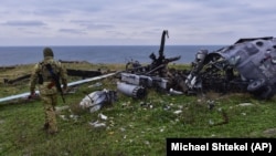 Український військовий на острові Зміїний у Чорному морі біля знищеного раніше російського гелікоптера, 18 грудня 2022 року, ілюстративне фото