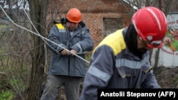 Workers repair broken power lines damaged by shelling in Ukraine's Donetsk region on November 25.
