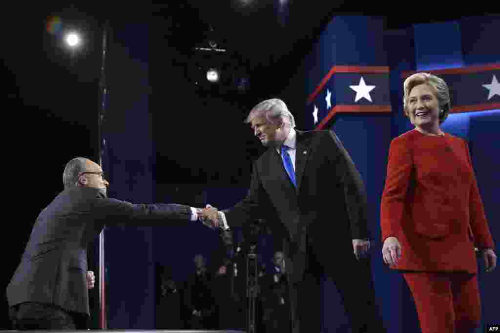 Donald Trump, kandidat republikanaca koji se rukuje sa moderatorom debate Lesterom Holtom, dolazi na prvu predsjedničku debatu na kojoj će svoja mišljenja suprotstaviti sa stavovima kandidatkinje demokrate Hillary Clinton.