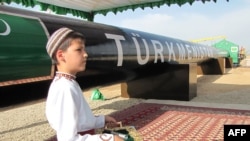 Türkmenistanda gaz geçiriji ulgamyň ýanynda duran oglan (Illýustrasiýa suraty)