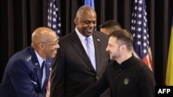 Președintele Statului Major interarme al SUA, generalul Charles Q. Brown (stânga) dă mâna cu președintele ucrainean Volodimir Zelenski.