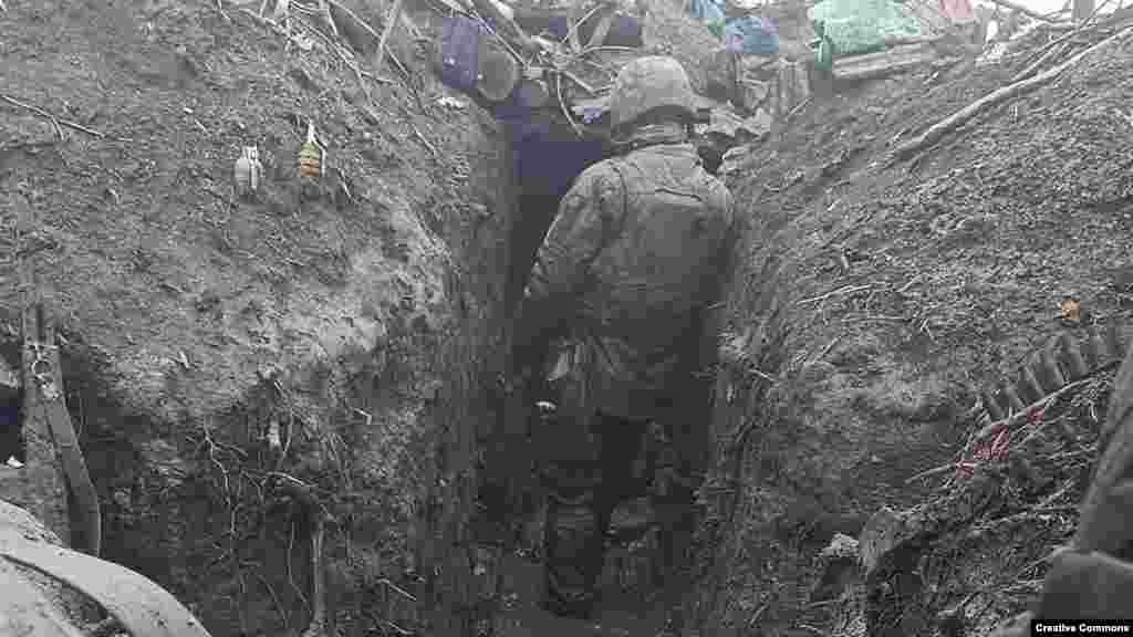 Un soldat ucrainean într-un șanț plin cu noroi în apropiere de Bahmut, în estul Ucrainei, în noiembrie.