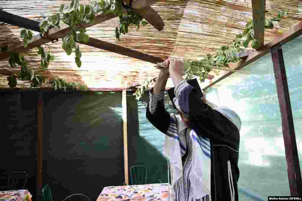 Na fotografiji izvodi obred mahanja svežnjem grana - palme, mirte i žalosne vrbe prilikom čega se izgovara molitva. Mahanje simbolizira okretanje najprije ka Jerusalemu, a onda na sve strane svijeta. 