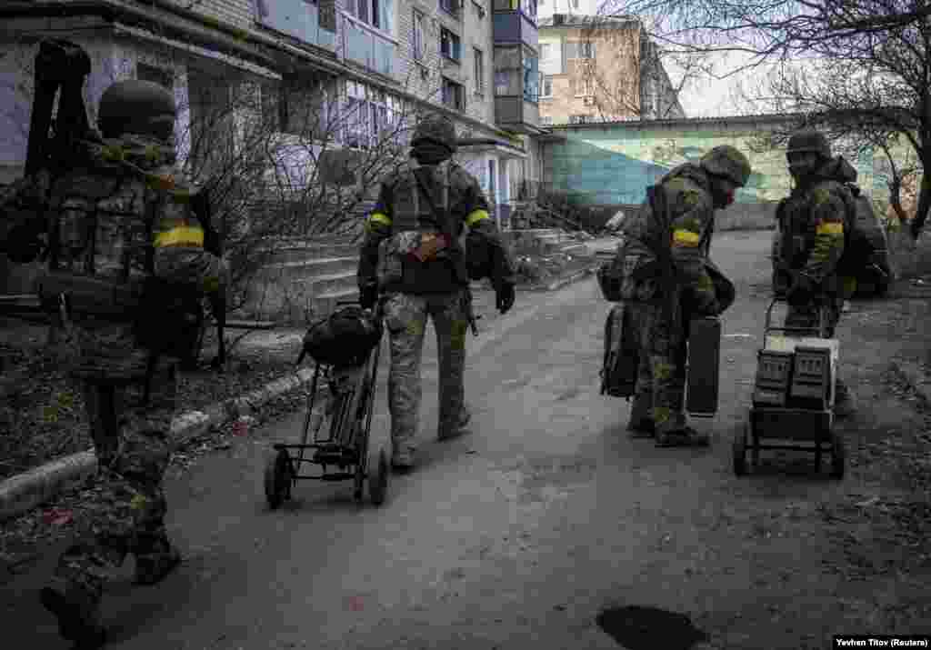 Українські військовослужбовці перевозять зброю та боєприпаси порожніми вулицями Бахмута, 7 грудня 2022 грудня. Західні союзники надали українським військовим окрім зброї та амуніції спорядження для ведення бойових дій в умовах зими 