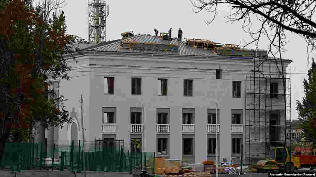 O fotografie din 21 august de la reconstrucția clădirii Filarmonicii din Mariupol. Lucrările de reconstrucție au început aproape imediat după preluarea puterii de către Rusia la unele clădiri din centrul Mariupol, dar imaginile din această galerie, publicate de Reuters la 30 octombrie, par să arate că zone vaste din oraș rămân nelocuibile. 