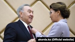 Дариға Назарбаева (оң жақта) әкесі Нұрсұлтан Назарбаевқа "құрметті сенатор" төс белгісін тапсырып тұр. 6 маусым 2019 жыл.