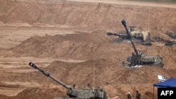 Самоодни артилериски возила „ховицер“ заземаат позиции за гаѓање во тековната битка меѓу Израел и Хамас, 28.12.2023