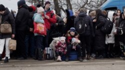 Deși așteaptă de trei zile în Ucraina pentru a trece frontiera în România, doi copii zâmbesc de pe valiza în care familia lor are toate lucrurile.