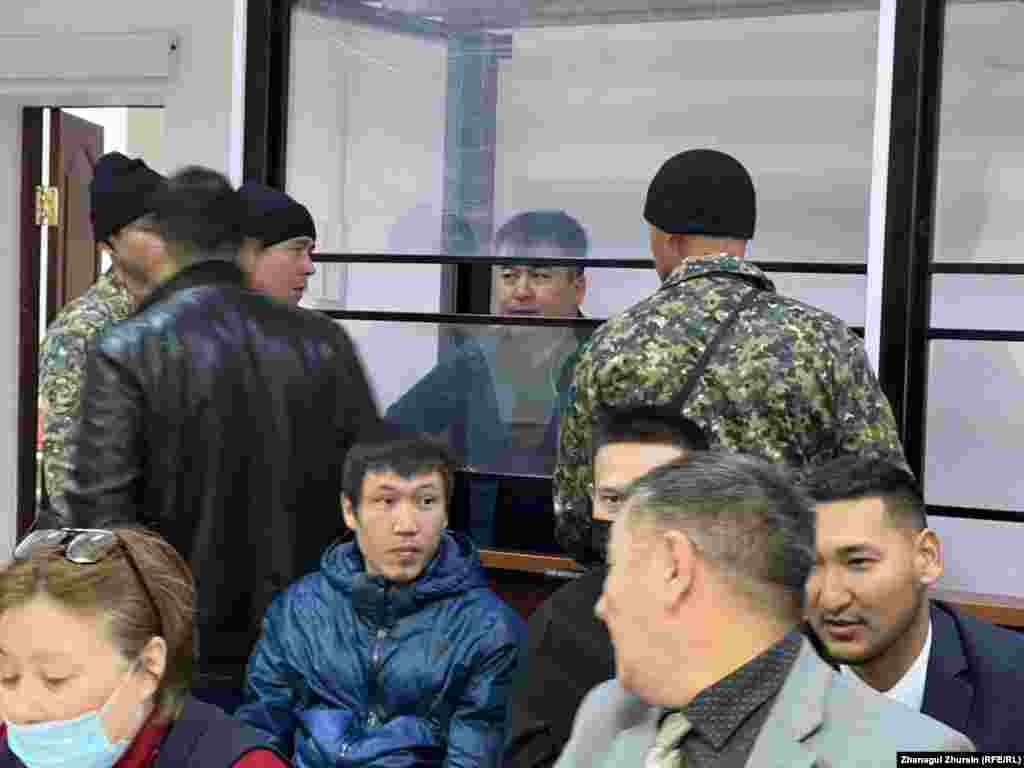 Содержащийся девятый месяц в изоляторе обвиняемый Ернур Ажниязов (в центре) в зале суда находится за стеклянной перегородкой 