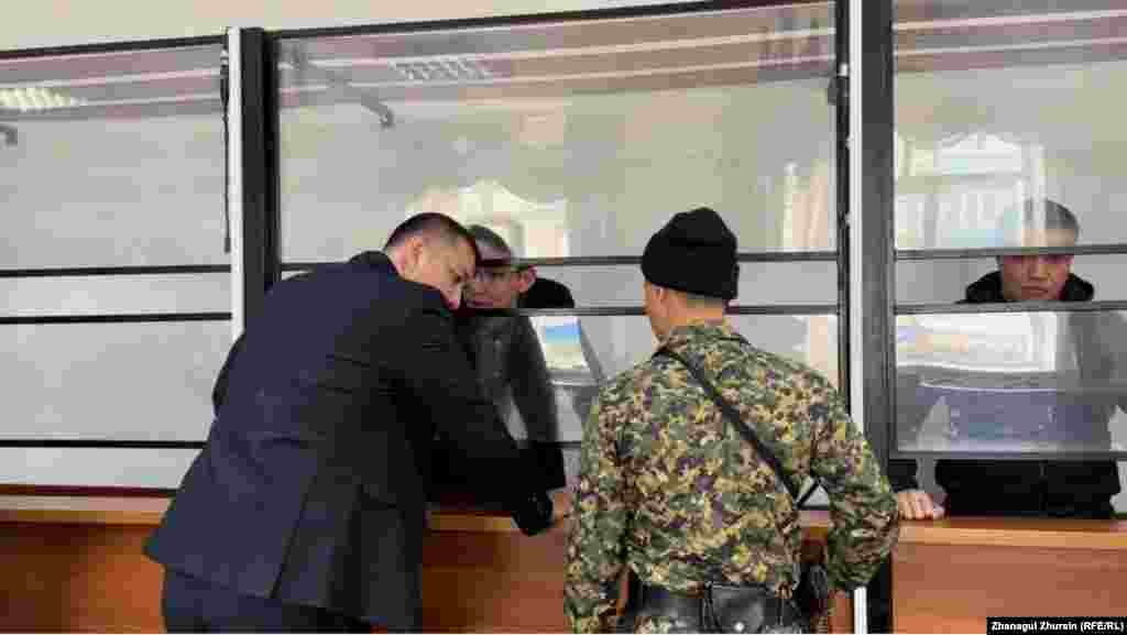 На заседании 19 октября адвокат Азамат Сагалов попросил суд освободить из-под стражи подзащитного Нурсултана Исаева. Суд это ходатайство не удовлетворил. На фото: Нурсултан Исаев (за стеклом) разговаривает с адвокатом Азаматом Сагаловым 